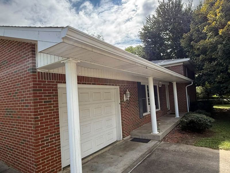 Clean white gutters on a covered front porch and garage near Louisville, KY
