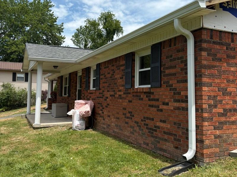 New white seamless gutters and downspout on a brick ranch home near Louisville, KY