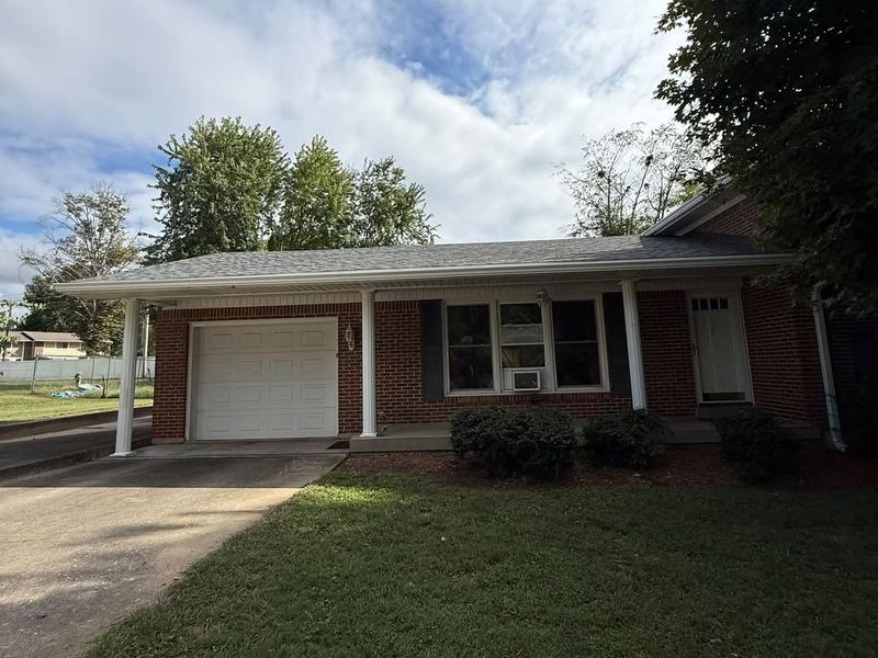 White gutters along the front porch and garage of a brick home near Louisville, KY
